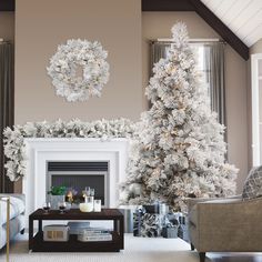 a living room decorated for christmas with white and silver decorations on the fireplace mantel