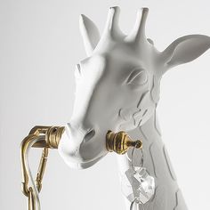 a white giraffe head with gold accents on it's face and neck