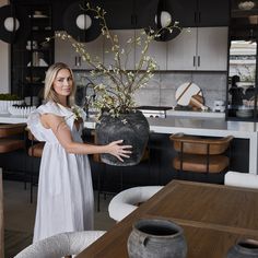 a woman holding a vase with flowers in it