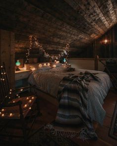 an attic bedroom with lights strung from the ceiling and bed in the corner, along with two rocking chairs