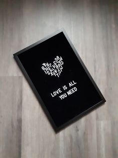 a black frame with white writing on it that says, love is all you need