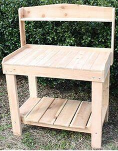 a wooden bench sitting in front of a bush