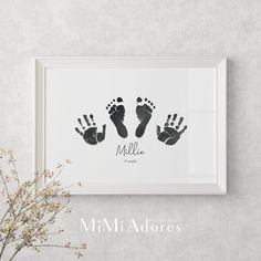 an image of a baby's hand and foot prints in a frame on the wall