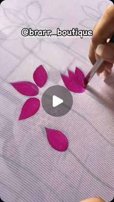 someone is painting flowers with pink paint on the paper and using a marker to draw them