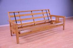 a wooden bench sitting on top of a hard wood floor next to a blue wall