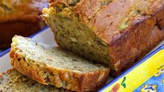 sliced banana bread sitting on top of a blue and yellow plate next to another loaf