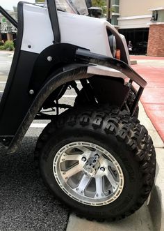 a white and black golf cart parked on the street