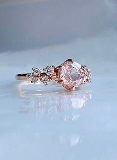 a pink diamond ring with three diamonds on it