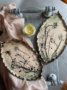 two plates sitting on top of a table next to a candle