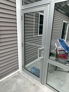 an empty lawn chair sitting in front of a sliding glass door