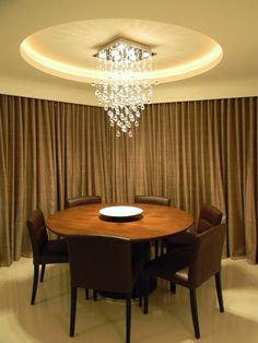 a dining room table with chairs and a chandelier hanging from it's ceiling