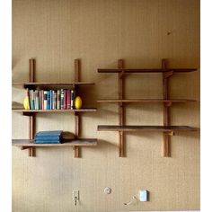 two bookshelves are next to each other on the wall, one is made out of wood