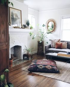 a living room filled with furniture and a fire place in front of a mirror on the wall