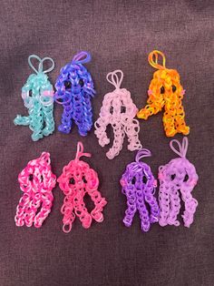 six crocheted letters are shown in different colors and sizes on a gray surface