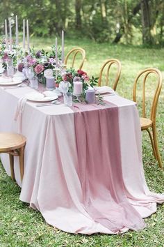 a table set with pink linens and candles