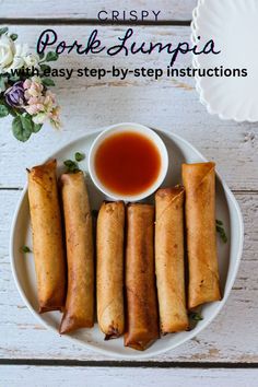 some food on a white plate with sauce and flowers next to it that says crisp pork lumpia