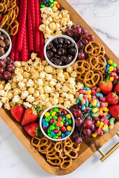 a platter filled with candy, pretzels, strawberries and other snacks