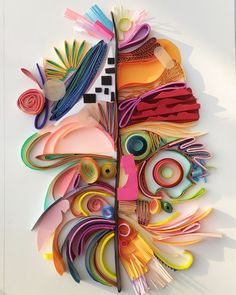 an art piece made out of different colored papers and paper machs on a white surface