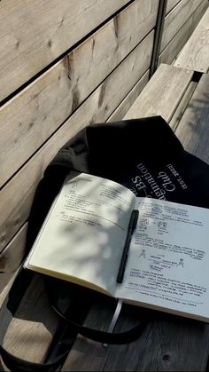 an open book sitting on top of a wooden bench