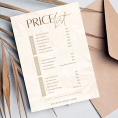 a price list sitting on top of brown envelopes next to some dried plants and paper