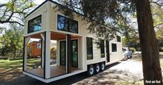 a tiny house on wheels is parked in the woods