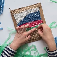 someone is working on an art project with yarn and paper streamers in the background