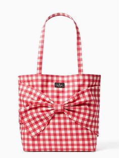 a red and white gingham bag with a large bow on the front pocket