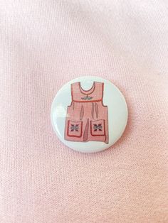 a white button with a pink dress on it