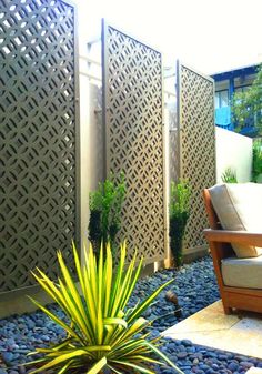 a small garden with rocks and plants in the foreground, an outdoor seating area on the other side