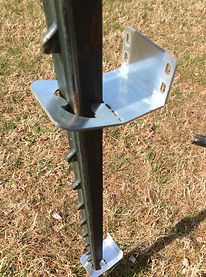 a metal pole sitting on top of a grass covered field