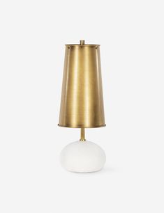 a white and gold table lamp with a light shade on it's base, against a white background