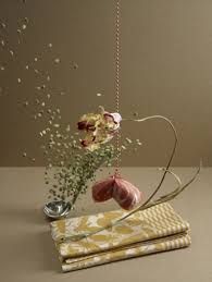 two napkins with flowers in them on a table next to a spoon and bowl