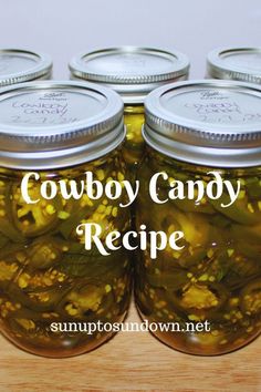 four jars filled with pickles sitting on top of a wooden table next to the words cowboy candy recipe