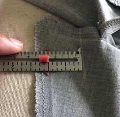 someone is measuring their jeans with a ruler on the bottom and one end of them