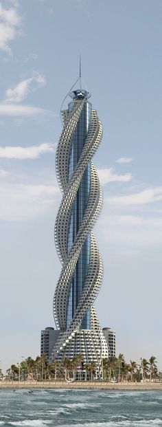 a very tall building with a spiral design on it's side in the ocean