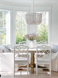 a dining room table with chairs and a chandelier hanging from it's ceiling