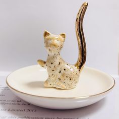 a cat figurine sitting on top of a white plate