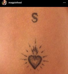 the back of a woman's stomach with a sun and heart tattoo on it