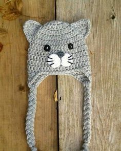 a crochet cat hat that is laying on top of a wooden floor