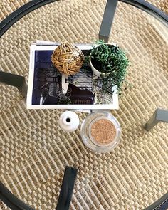 a glass table with some plants on top of it next to two rolls of thread