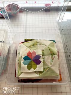 the quilts are being sewn together and placed in plastic containers on the table