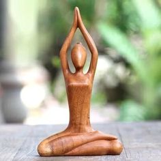 a wooden statue of a person doing yoga