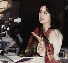 a woman sitting at a table in front of a microphone