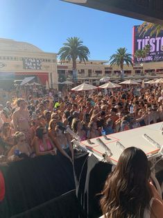 a large group of people sitting at tables in front of a crowd