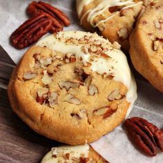 several cookies with white icing and pecans around them