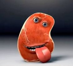 an orange object with blue eyes and tongue sticking out from it's mouth, in front of a dark background