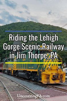 a yellow and green train on the tracks with mountains in the background text reads riding the lengh gorge scenic railway in jim thore, pa