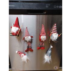 christmas gnomes are hanging on the refrigerator