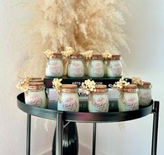 there are many jars on the table with some flowers in them and one is filled with baby's breath