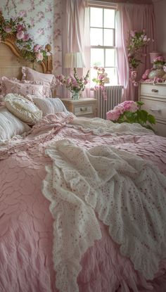 a bedroom with pink bedding and flowers in the window sill on the wall